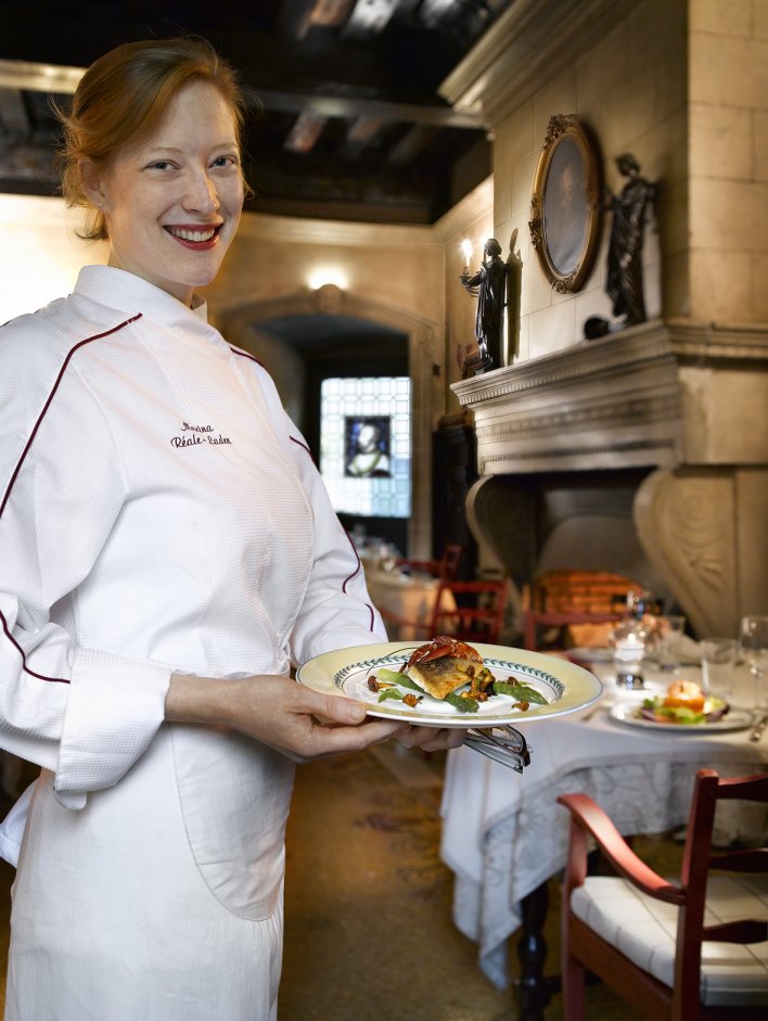 la restauratrice Marine tenant en veste de cuisine tenant présentant un de ses plats entre ses mains