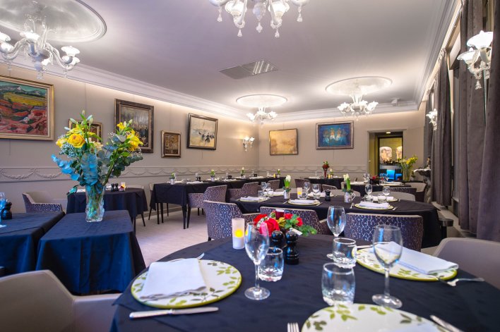 Salle de restaurant moderne et colorée avec tables dressées à l'hôtel La Terrasse à Douai