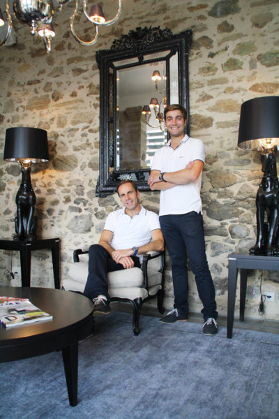 Portrait en pied de 2propriétaires dans une salle aux vieilles pierres apparentes