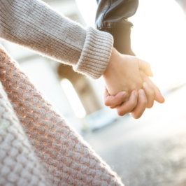 Gros plan sur une main féminine et une main masculine entrelacées