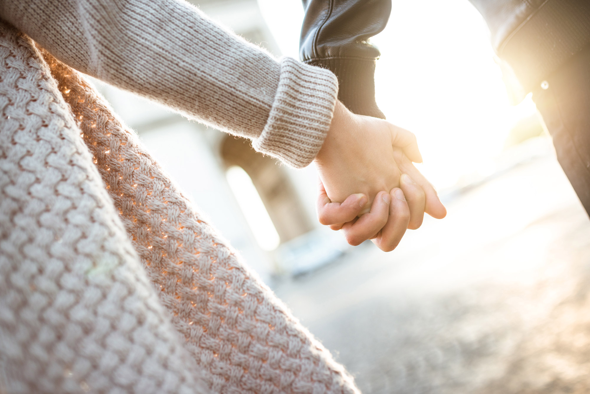 Gros plan sur une main féminine et une main masculine entrelacées