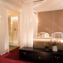 Spacieuse chambre à l'ambiance romantique avec coffre au pied du lit, baignoire et grand douche, lit king size