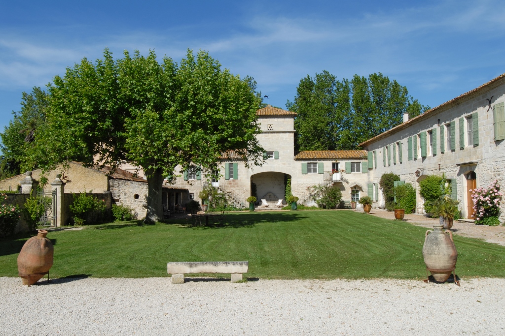 Cours avec carré de verdure et anciens bâtiment en " L "