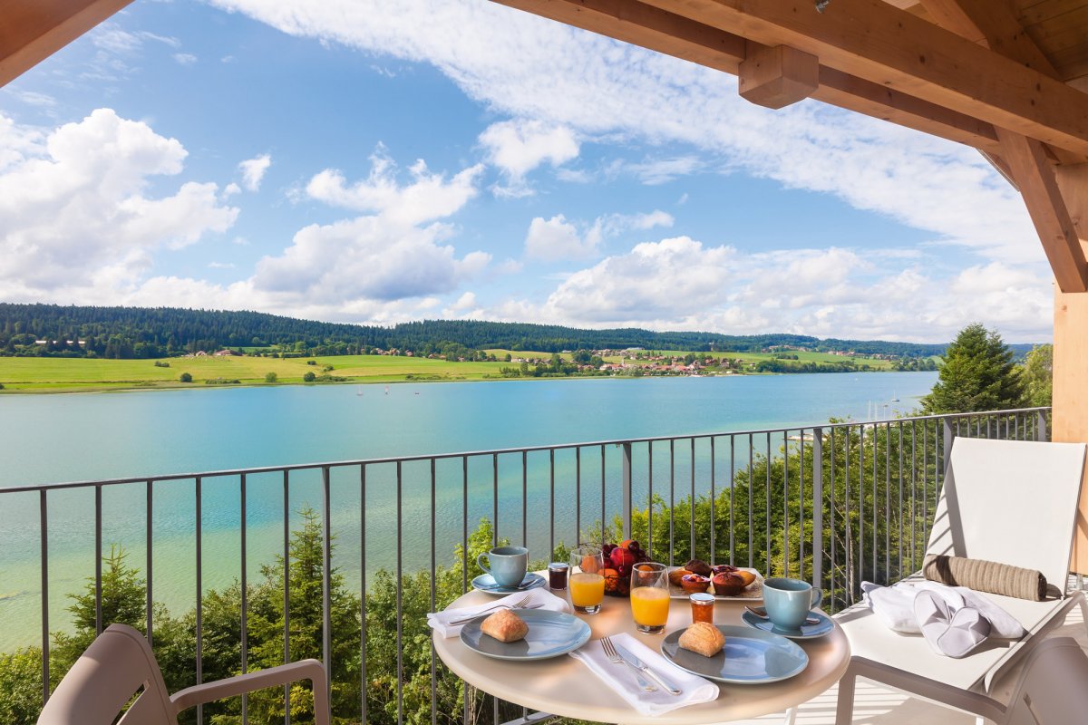 Petit-déjeuner convivial servi en terrasse avec vue splendide sur le Lac Saint Point