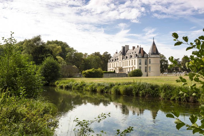 Château entouré de végétation d'un plan d'eau