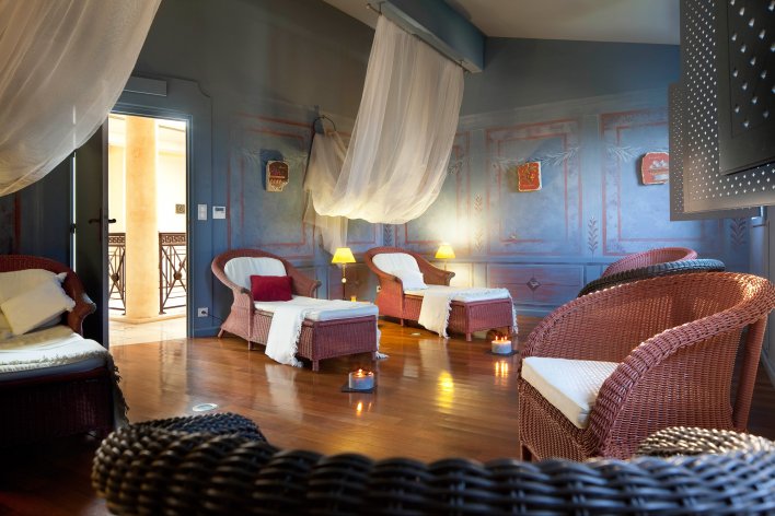 Grande salle dédiée aux soins et à la détente dans une ambiance feutrée et cocooning, meublée de fauteuils de relaxation en osier.