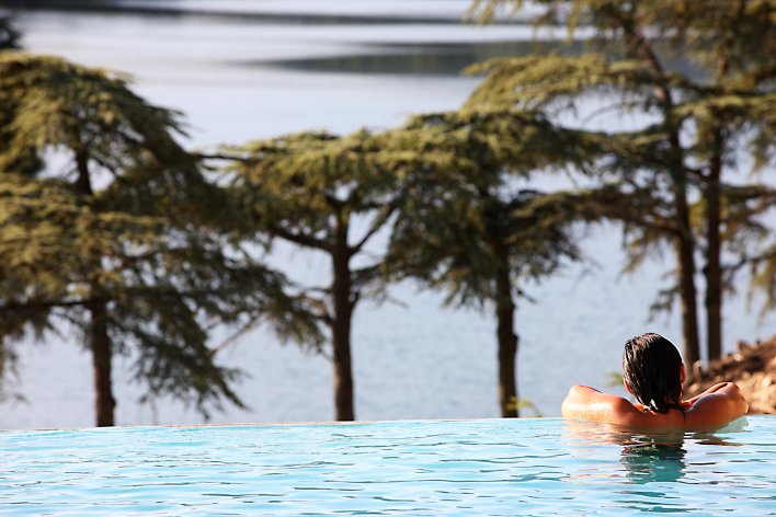 Piscine à débordement avec femme sur le rebord dans la piscine