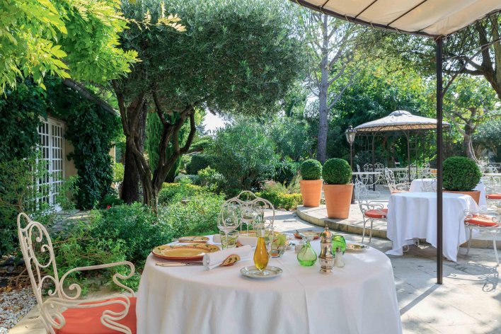 Terrasse table fer forgé et petits buissons