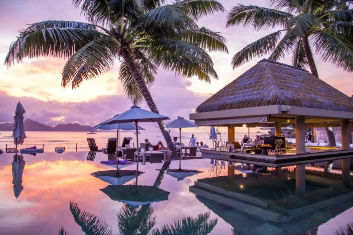piscine à débordement devant la mer et les palmiers aux Seychelles