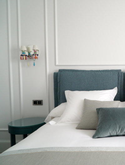 Détail tête de lit coussin bleu gris blanc et suspension colorée