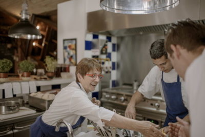 Photo d'une femme chef et de deux cuisinier en cuisine en tablier bleu