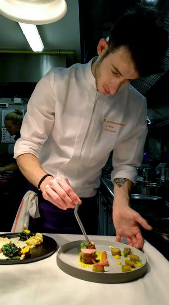 Photo de chef en veste de cuisine pendant le dressage d'un plat
