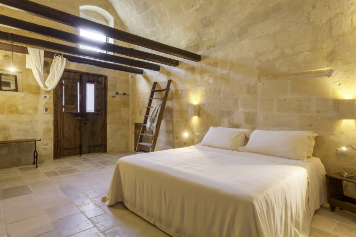 chambre lit double linge blanc et poutres apparentes