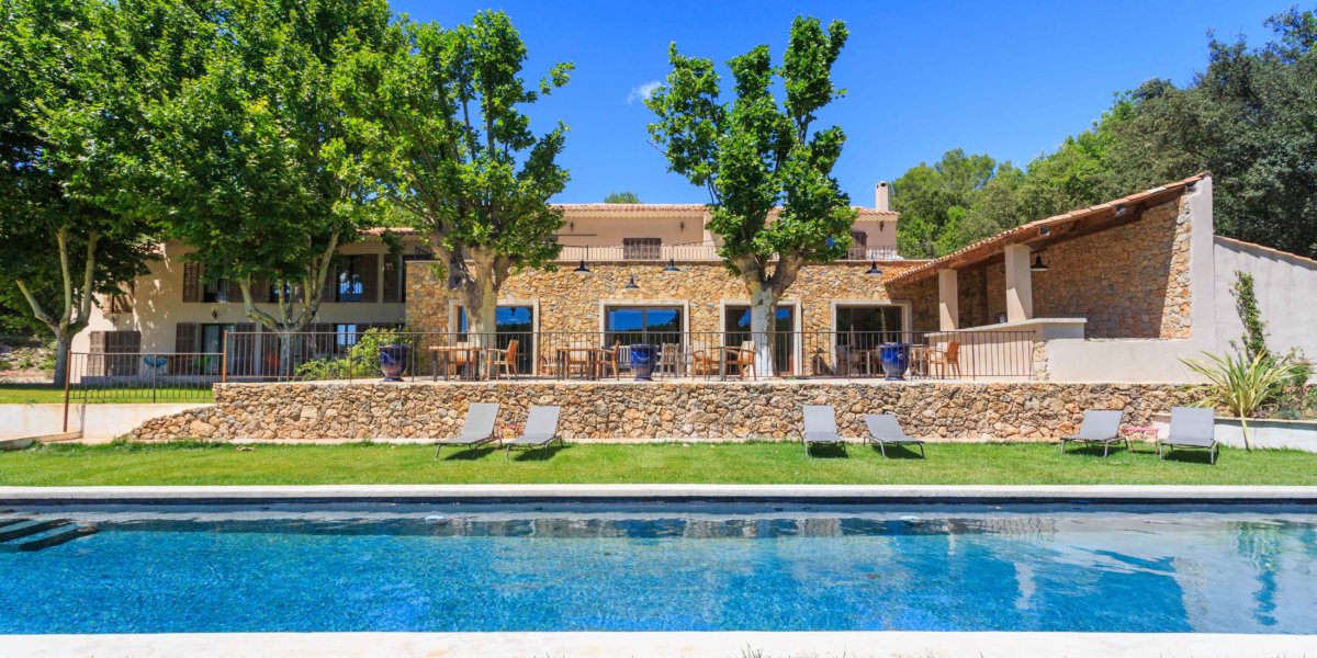 piscine extérieur devant bâtisse provençale et transats