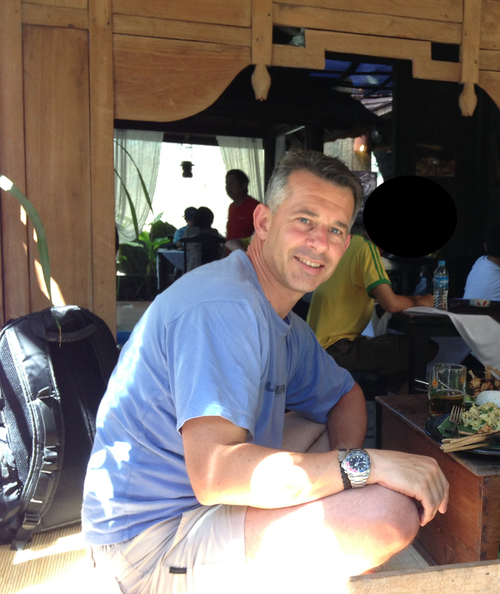 Portrait d'un homme en t-shirt bleu ciel dans une cabane typique de Bali