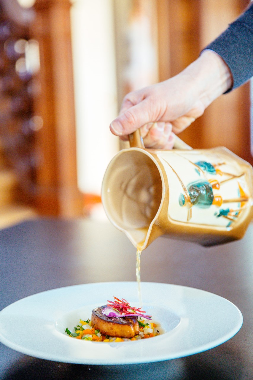 Plat de canard et saucière versant sur le plat