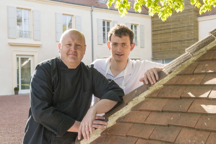 photo de deux chefs contre un toit en ardoises ocre