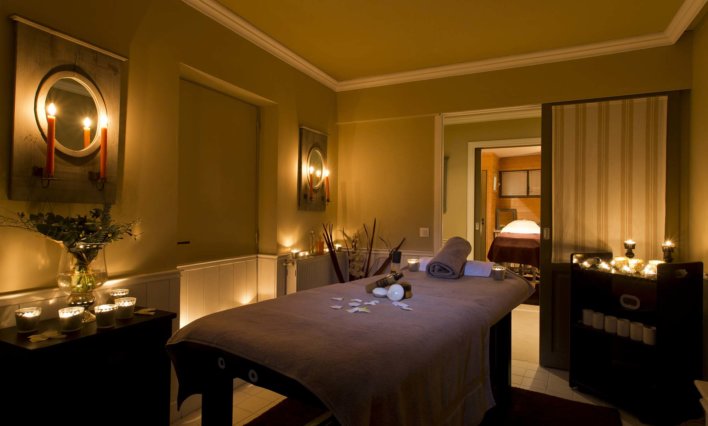Salle de soin spa avec banc de massage et lumière tamisée