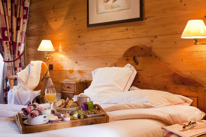 Chambre boisée, lit linge blanc et plateau petit-déjeuner