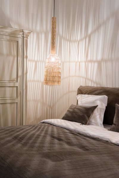 Détail tête de lit et suspension en rotin illuminée