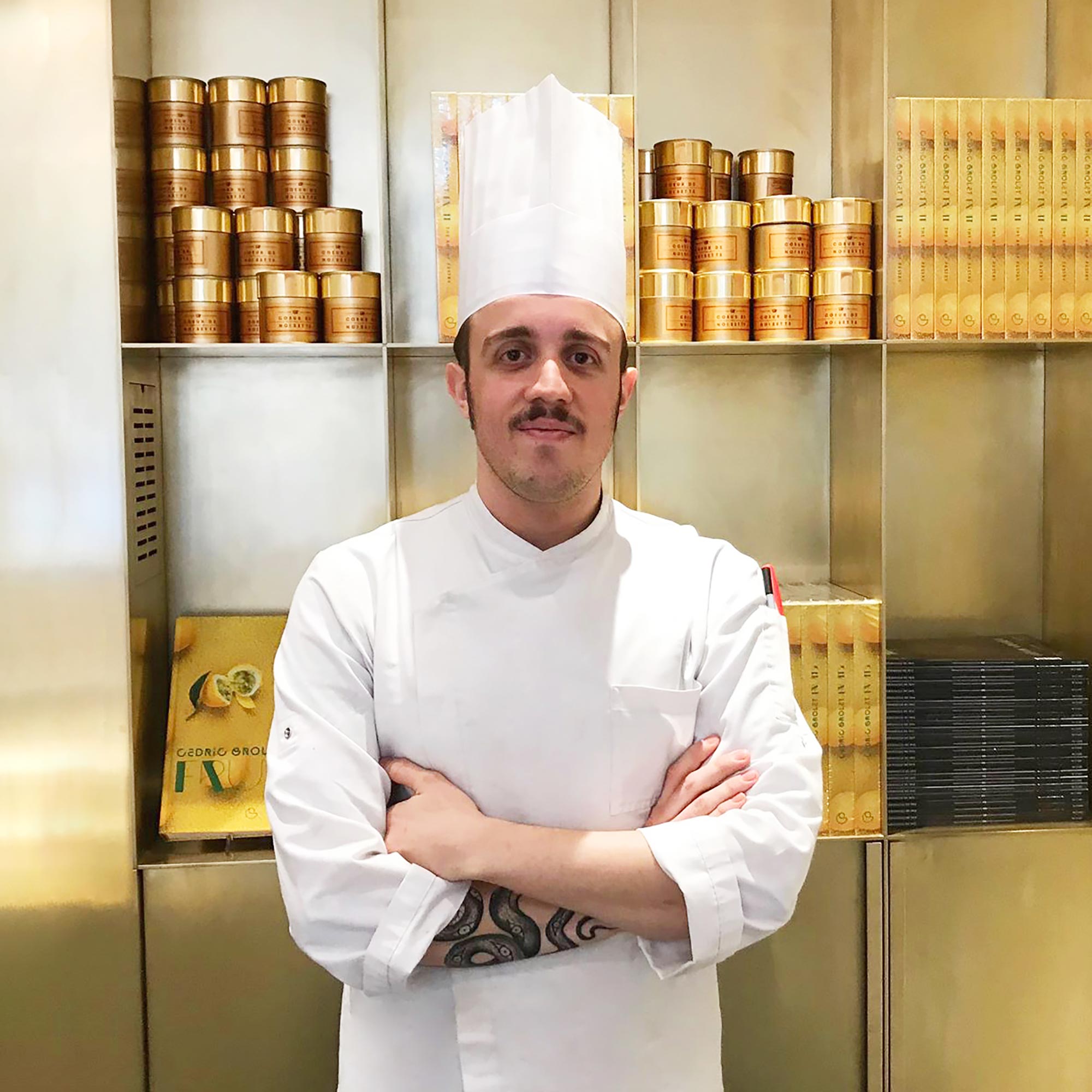 Plan américain d'un chef en veste de cuisinier et toque blanche