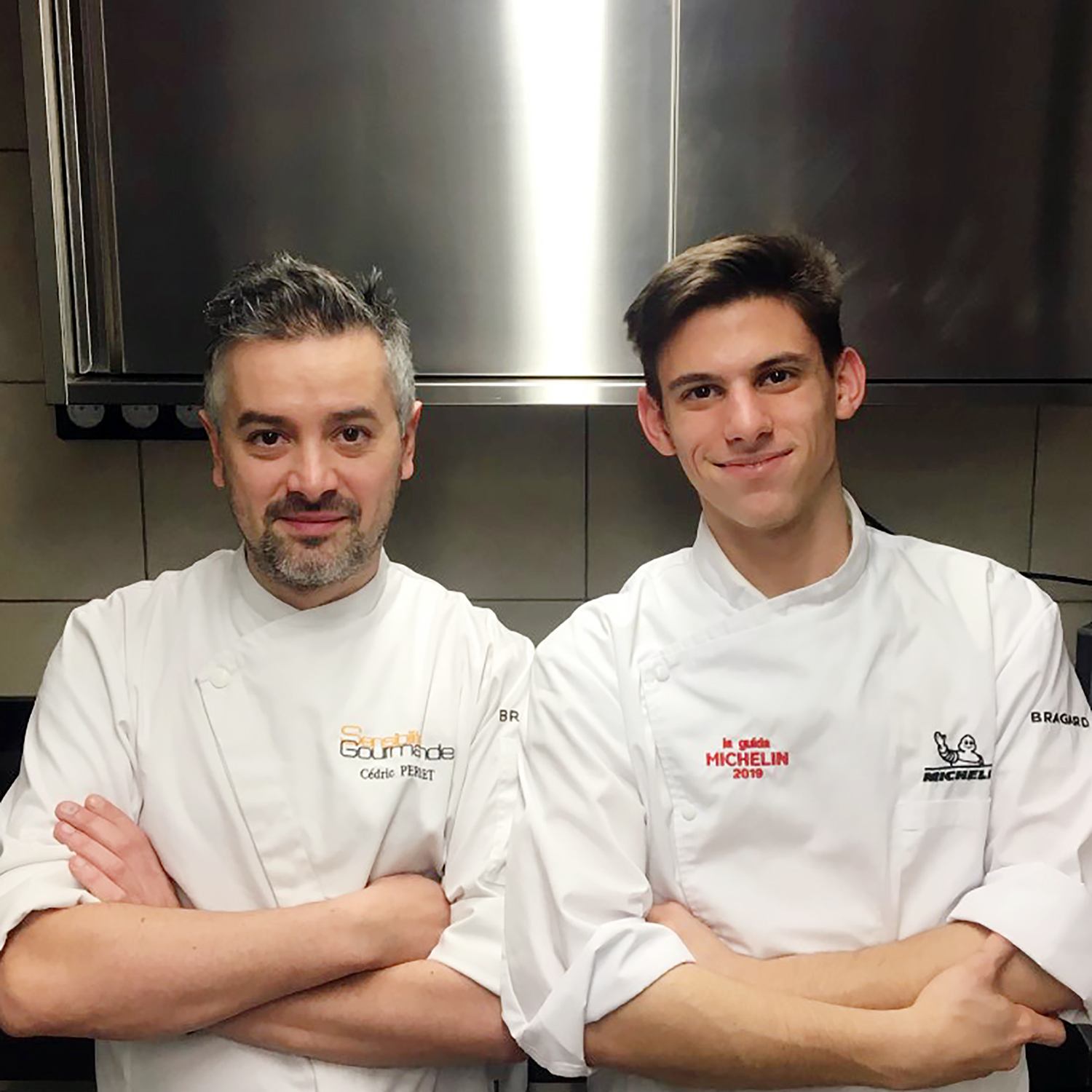 Photo plan américain de deux chefs en veste de cuisiniers, arrière plan cuisine