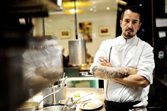 Le Chef Olivier Da Silva debout dans sa cuisine, les bras croisés