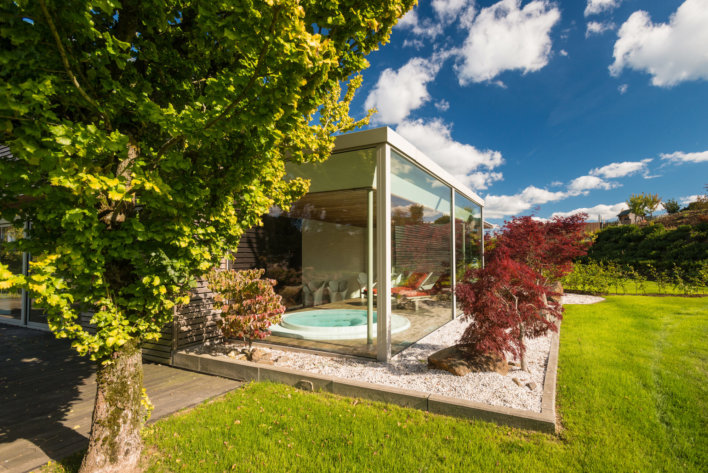 Jacuzzi extérieur vitré avec un,e belle vue sur l'espace vert de l'établissement