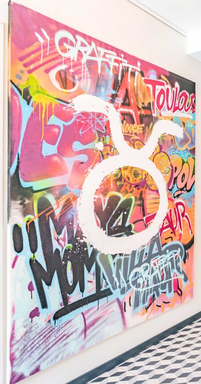 Toile peinte en graffiti, bombe de toutes les couleurs avec un logo qui blanc comme un oméga inversé