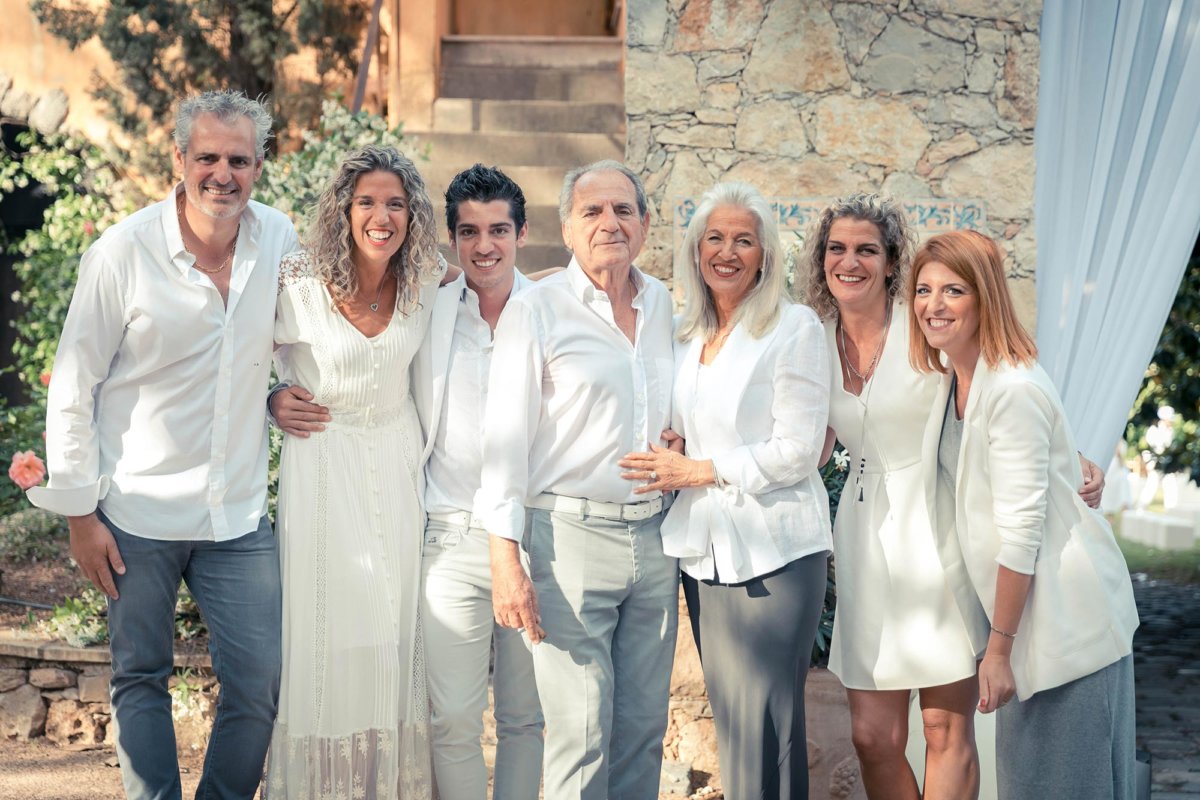 Photo de famille, hommes et femmes, en tenues blanche, bâtisse provençale en arrière-plan