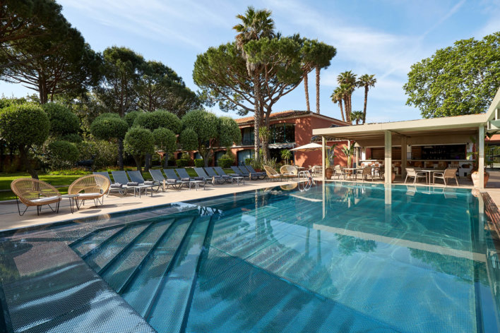 photo de la piscine extérieure prise en plein jour avec les transats au bord de la piscine