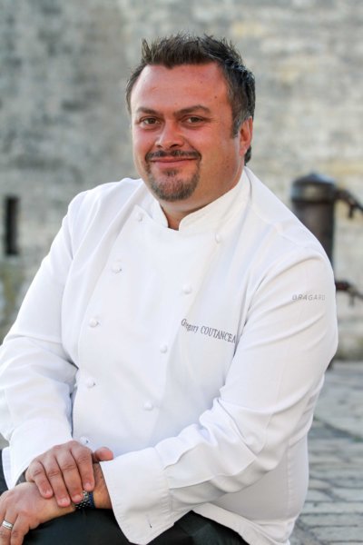 Portrait d'un chef en veste blanche brodée au nom du chef Grégory Coutanceau