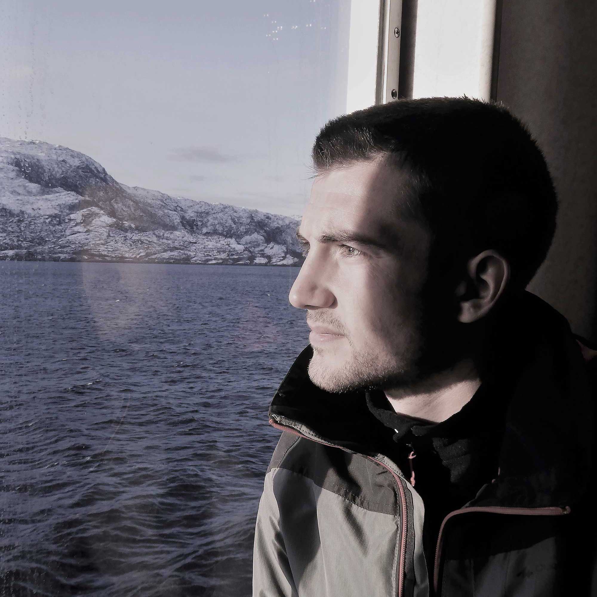 Photo portrait d'un homme de profil dans une cabine de bateau le regard contre la vitre