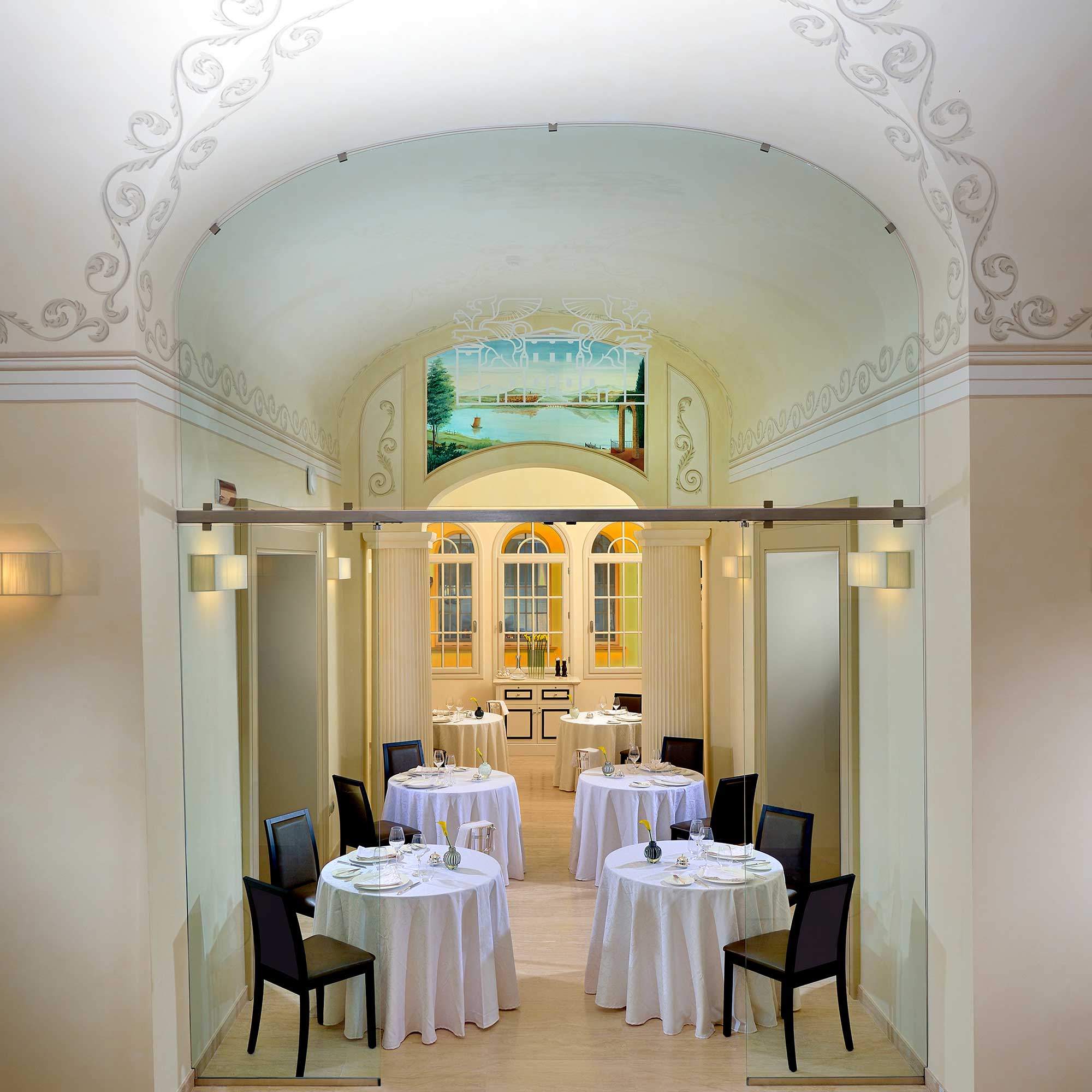 Salle de restaurant sous alcôves avec tables nappées blanches
