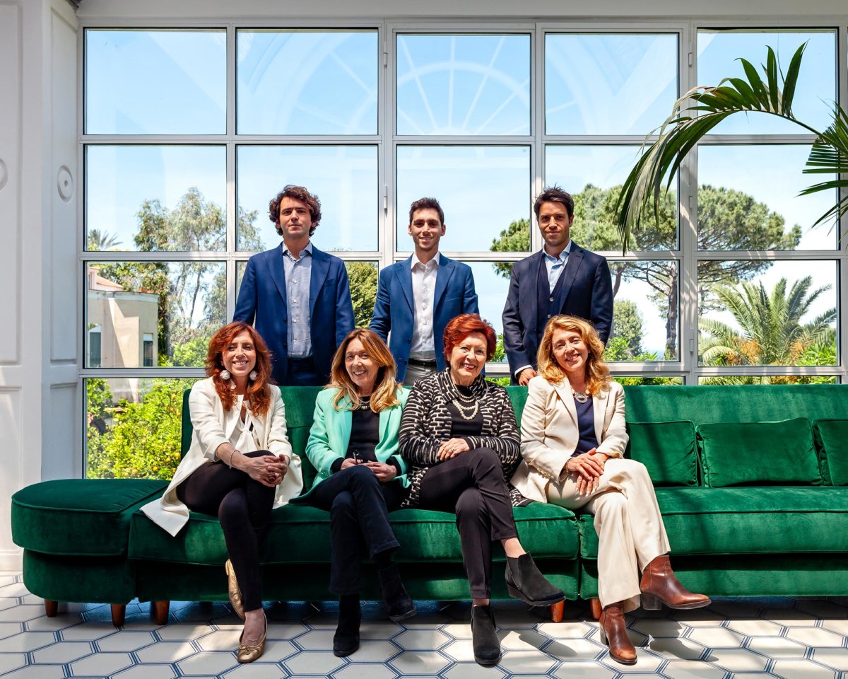 Photo de famille avec sept personnes, quatre femmes assises et trois hommes derrières debout