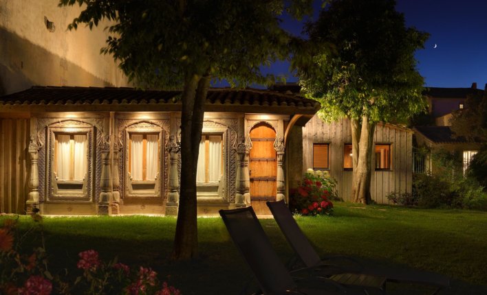 Cabane en bois dans un jardin à la nuit tombée