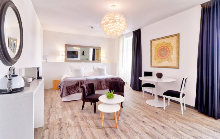 Photo de la chambre Belfry & Spa avec une petite table basse et un petit fauteuil violet situé devant le lit