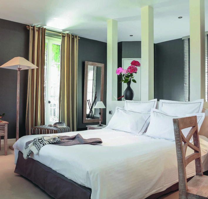 chambre avec un lit au milieu de la chambre et un couvert