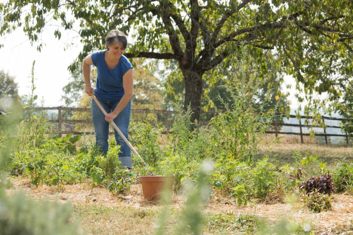 femme dans un potager en train de biner un terrain