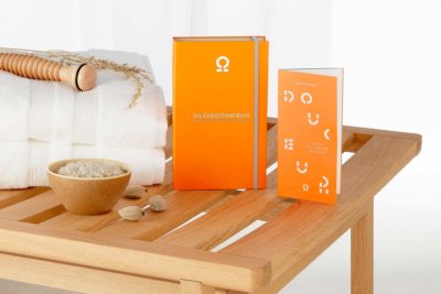 Coffret cadeau poser sur un support de SPA avec deux serviettes pliées et un petit bol de sel de mer