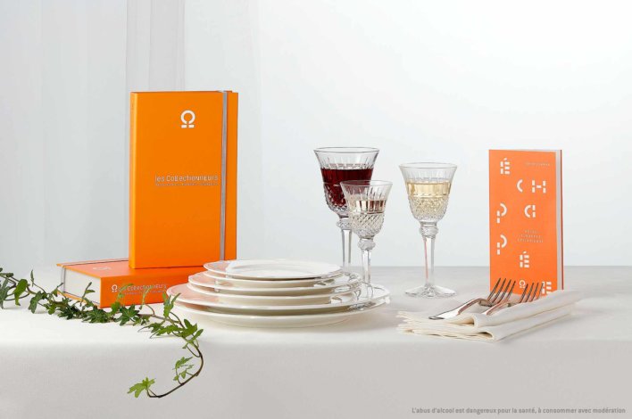 Coffret sur une table nappée d'une nappe de couleur blanche avec un assortiment de couverts et d'assiettes