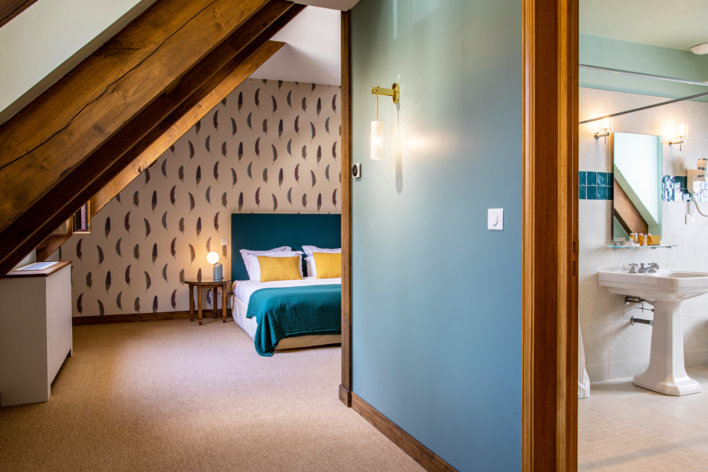 Photo prise au loin de la chambre avec un aperçu de la salle de bain