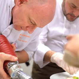 Deux chefs en cuisine prépare nue assiette à l'aide d'un siphon