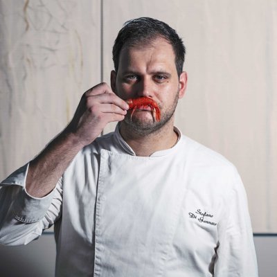 Chef avec une écrevisse dans la main déposer comme une moustache