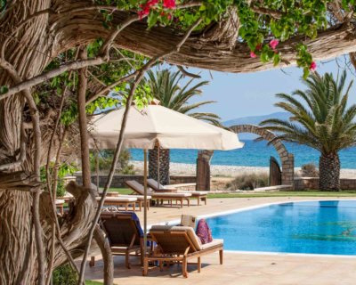 Piscine extérieure avec transat et une voyageuse qui lit