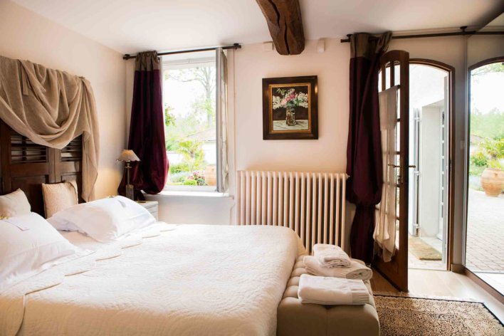 Chambre lit double, linge blanc et fenêtre ouverte