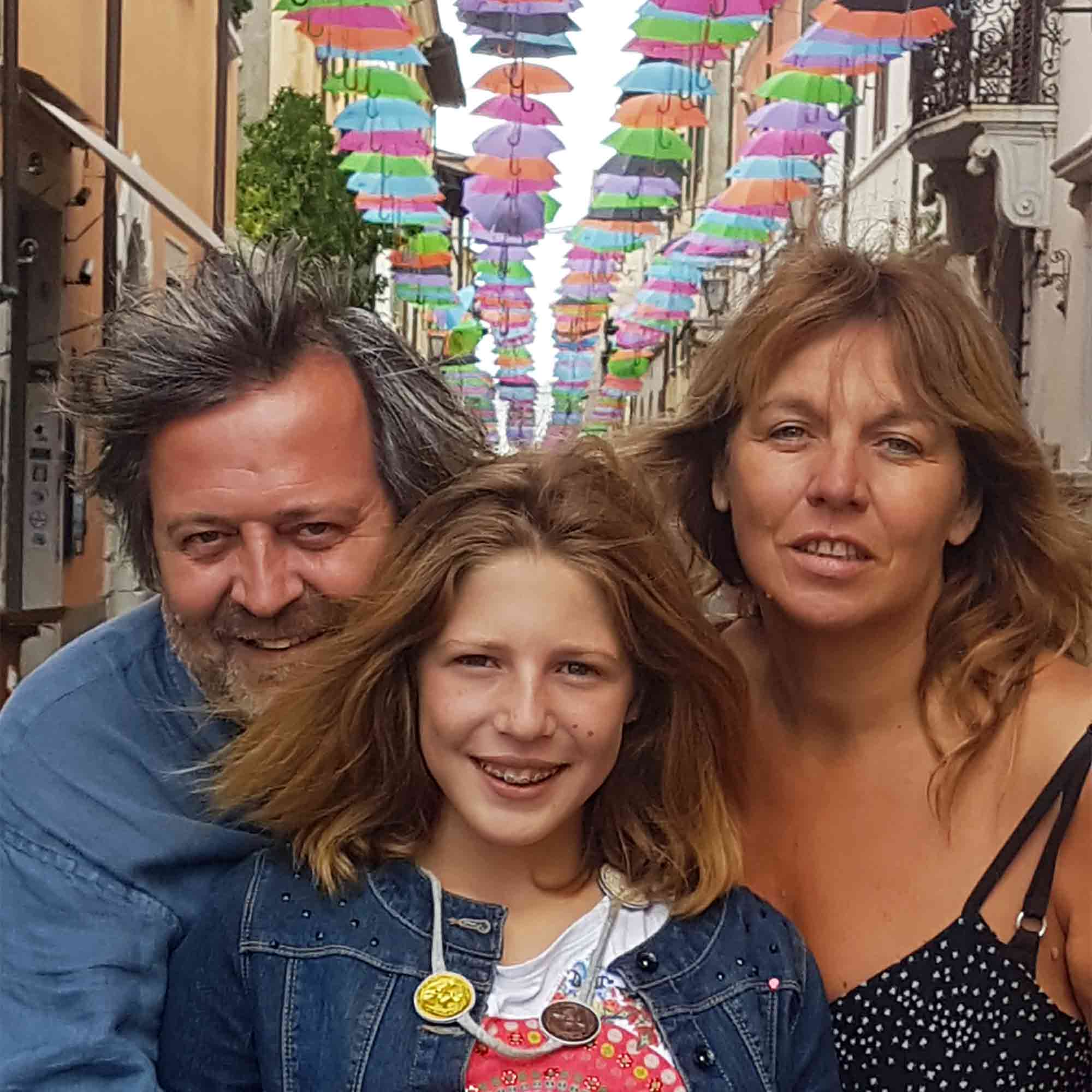 Photo de famille avec un père à gauche, une petit fille au milieu et une mère à droite