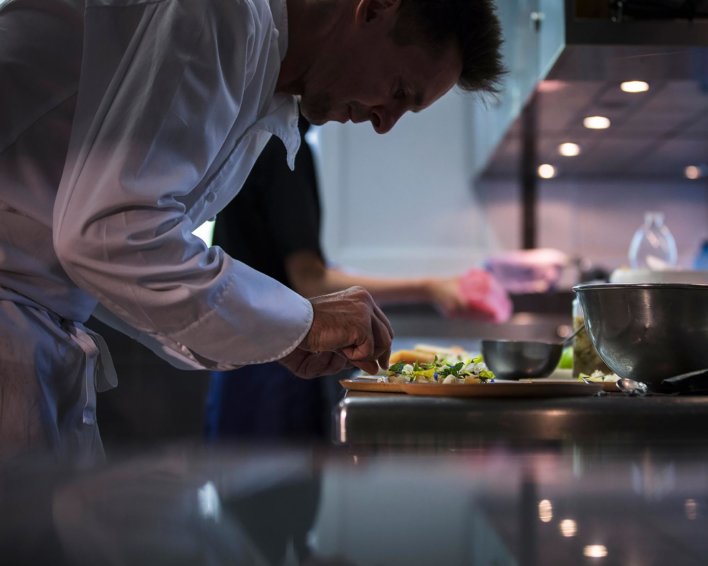 Un chef en cuisine dresse un plat